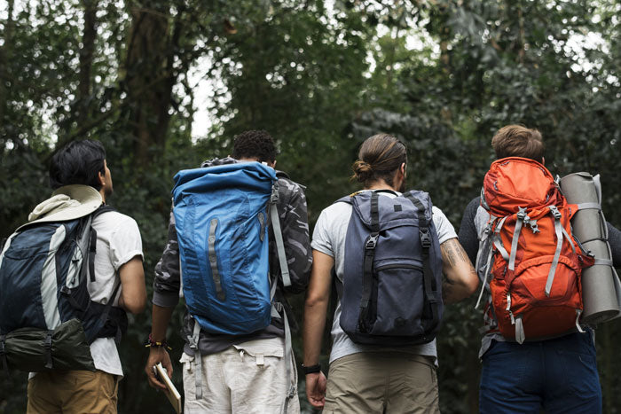 Hikers wearing layering system apparel and carrying backpacks during a 5-day outdoor trek.